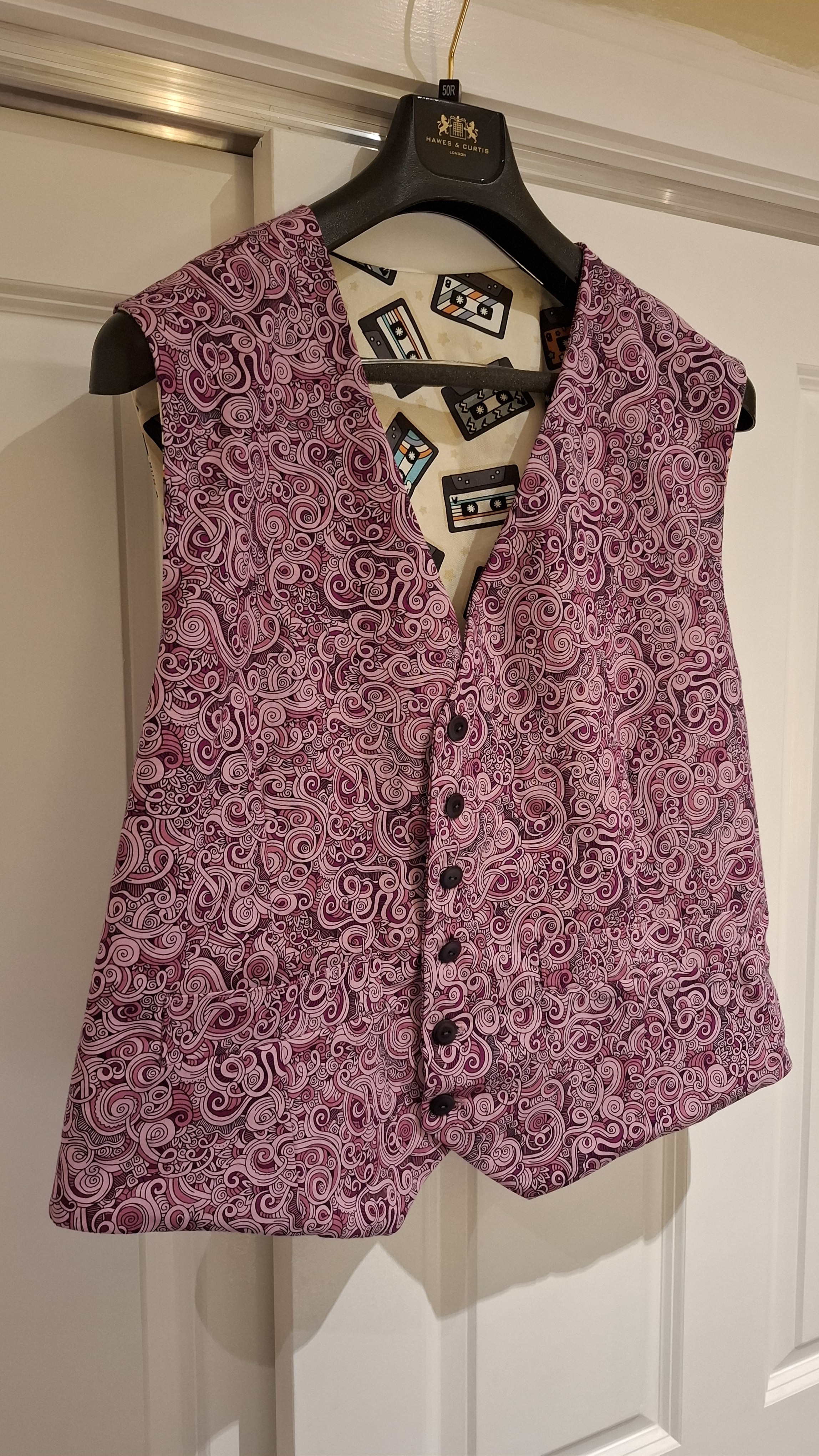 A tailored paisley waistcoat, hand-sewn, on a hanger