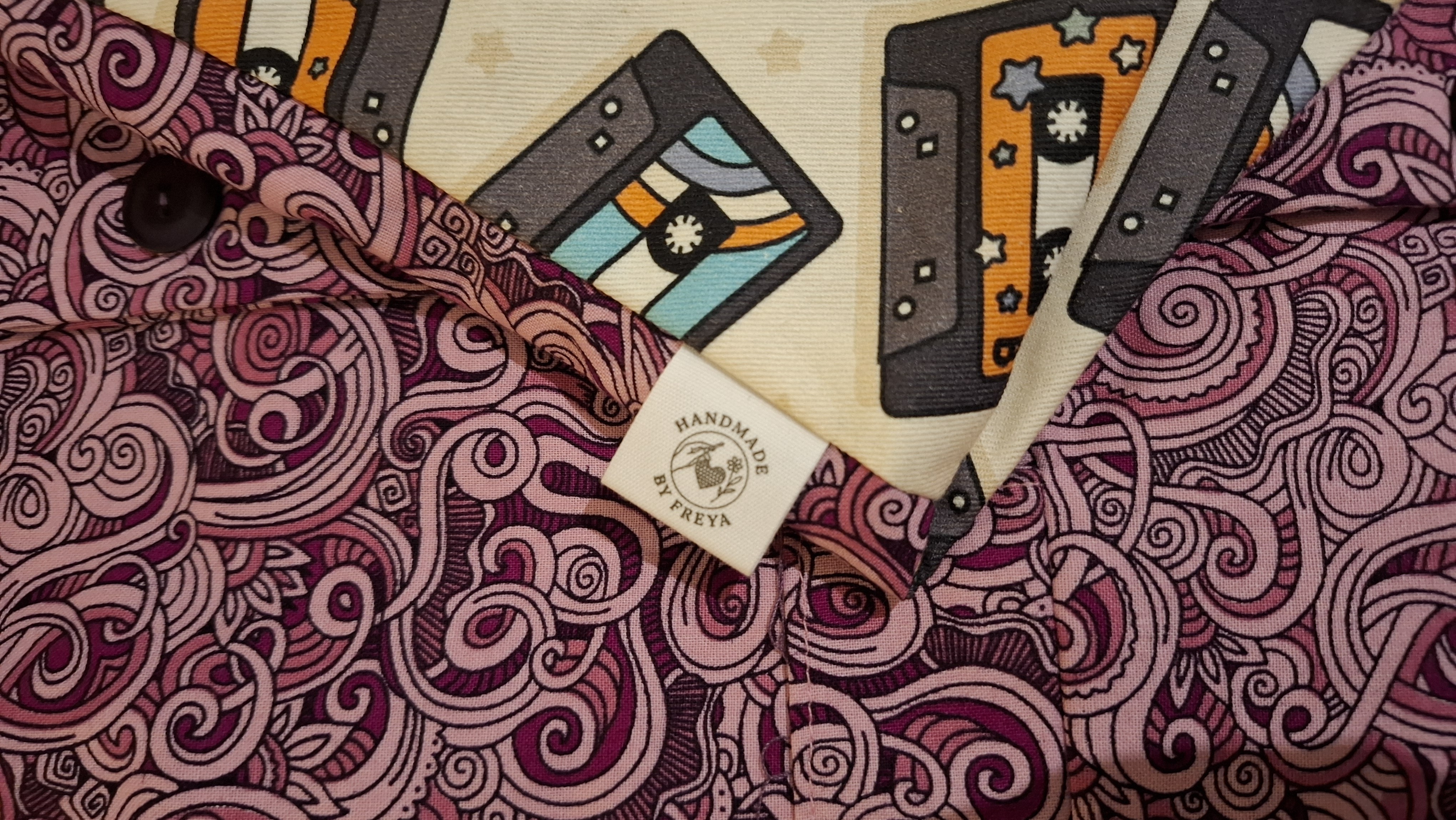 Close-up of the waistcoat's cassette-tape lining and a woven Handmade by Freya label