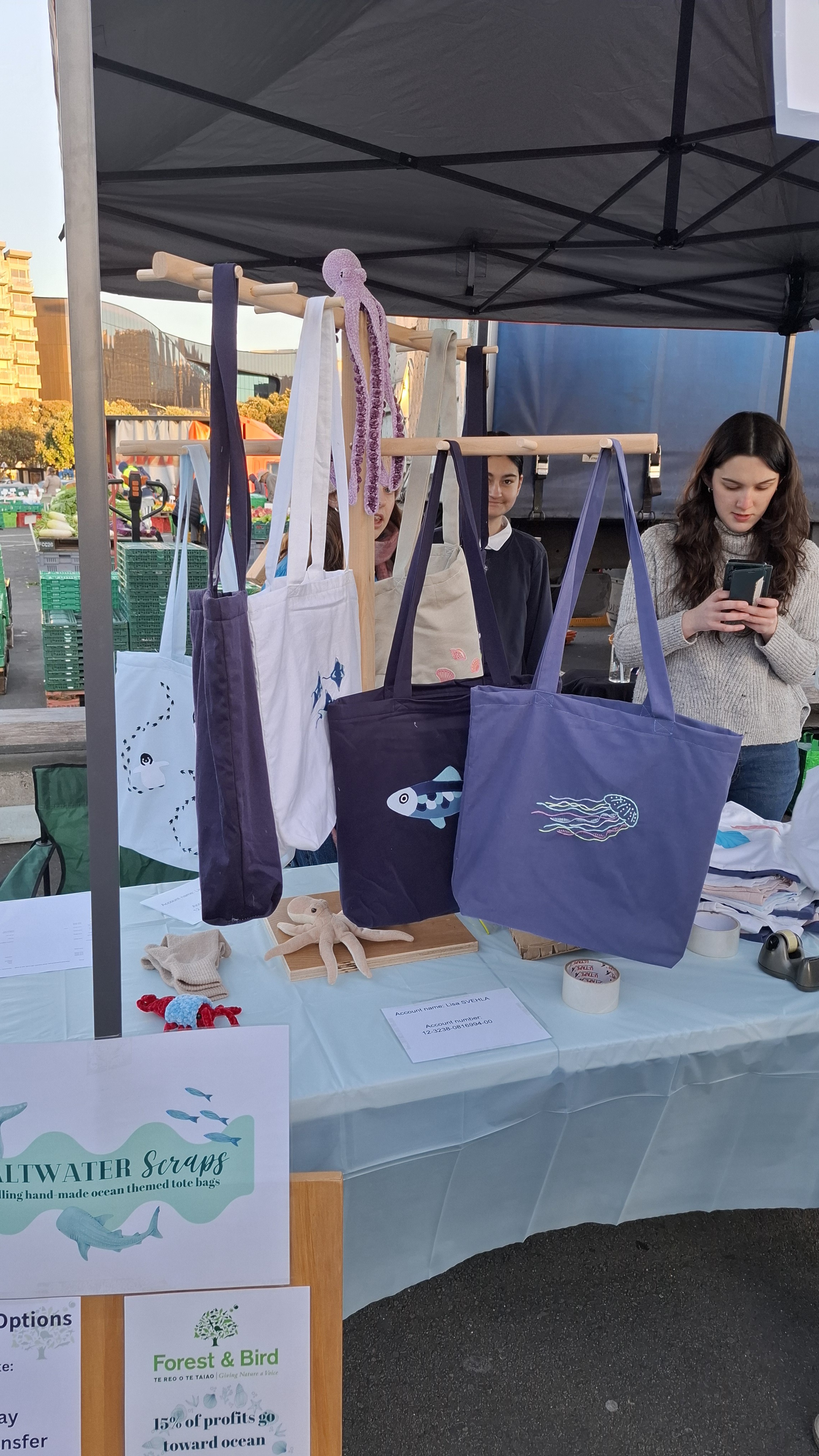 The Saltwater Scraps market stall with tote bags and handmade pieces on display